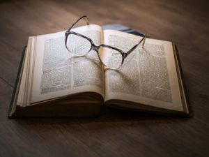 aufgeschlagenes Buch mit Brille